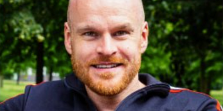 male with bald head and ginger beard smiling 