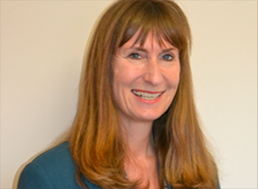 female with long auburn hair smiling
