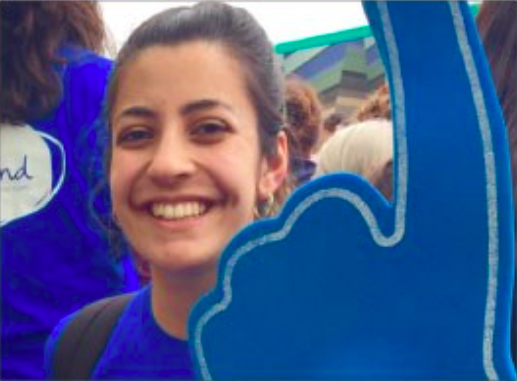 female holding a blue foam finger wearing a blue top with mind logo