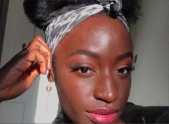 female with white and grey head band smiling 