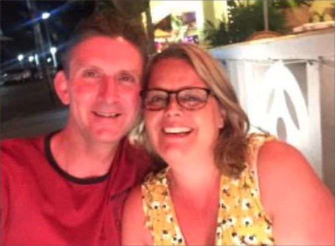 A male and female smiling with their heads together