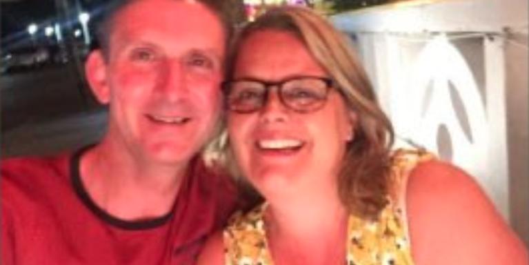 A male and female smiling with their heads together
