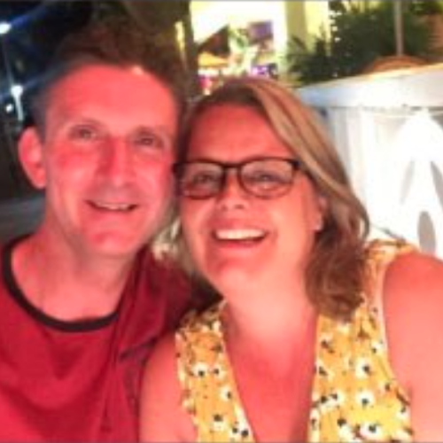 A male and female smiling with their heads together