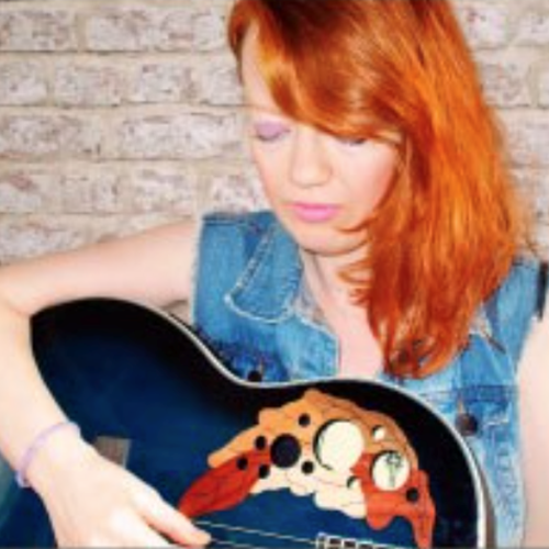 female looking down at the guitar in her lap