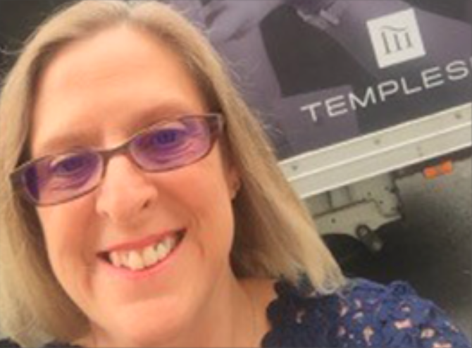 female smiling wearing purple tinted glasses