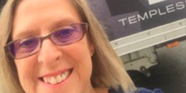 female smiling wearing purple tinted glasses