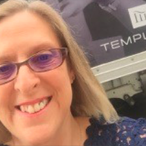 female smiling wearing purple tinted glasses