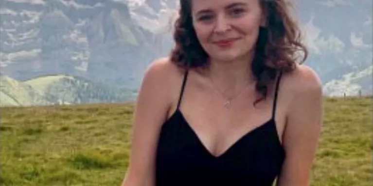 female smiling with mountains in the background