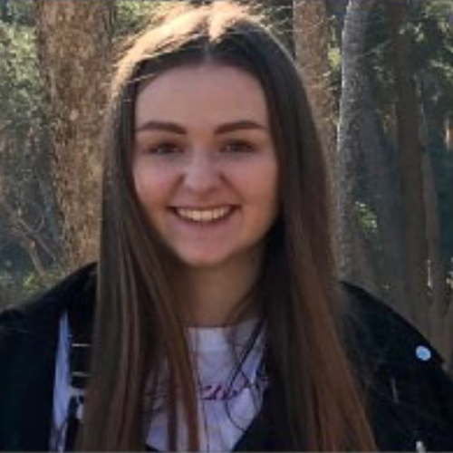 female smiling with forest behind