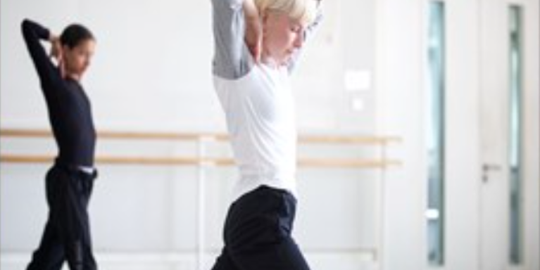 two females doing the same dance pose in a dance studio