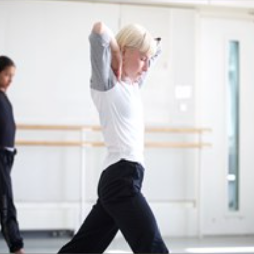 two females doing the same dance pose in a dance studio