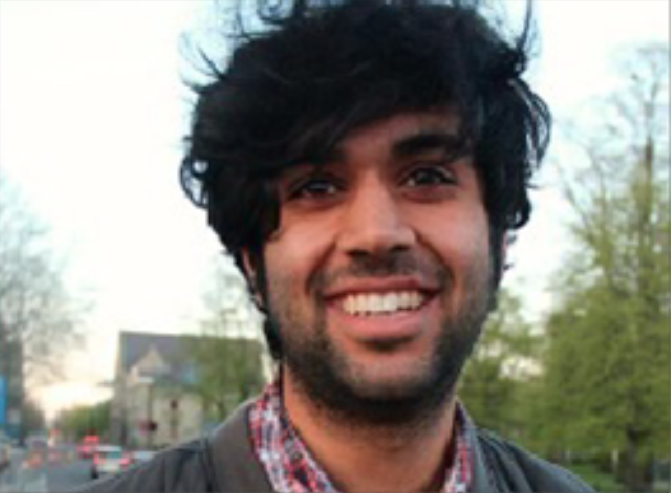male with very black, thick hair smiling