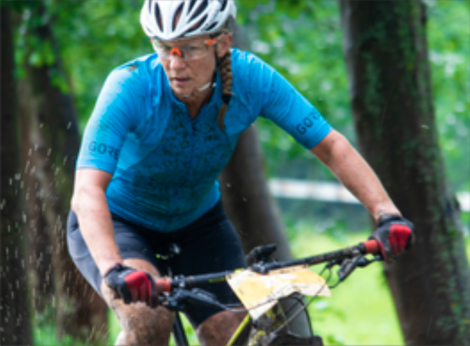 female muddy and on a bicycle