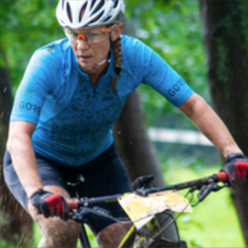 female muddy and on a bicycle