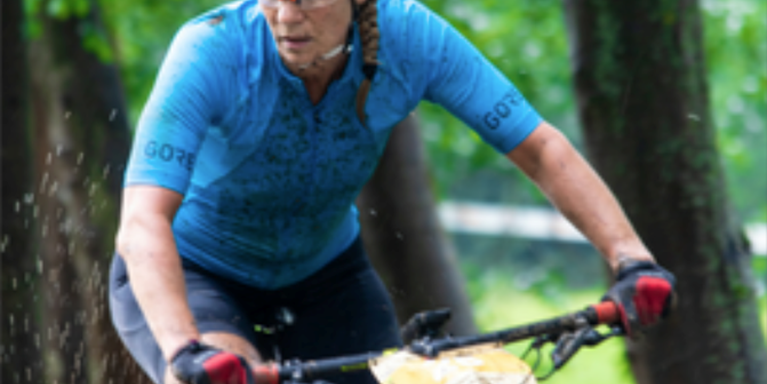female muddy and on a bicycle