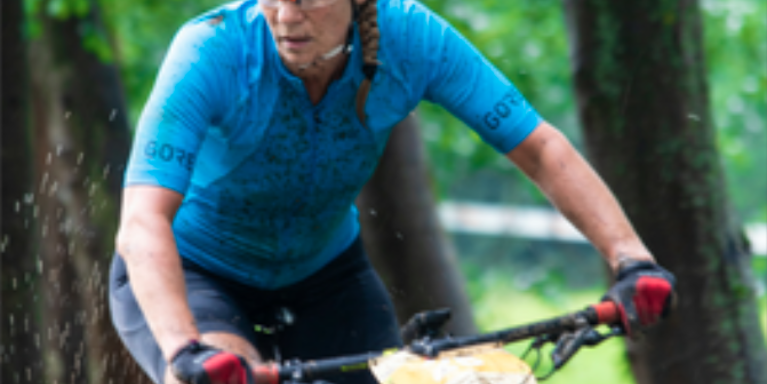 female muddy and on a bicycle