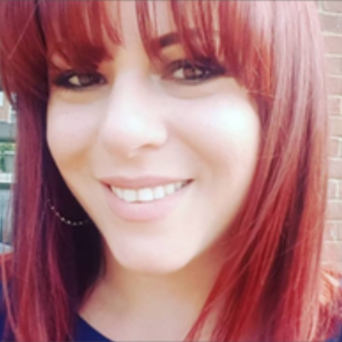 female smiling, with a full fringe and red hair