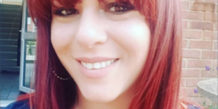 female smiling, with a full fringe and red hair