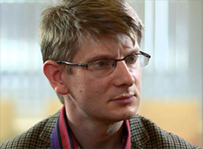 male wearing glasses looking to the right