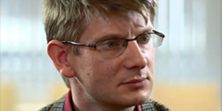 male wearing glasses looking to the right