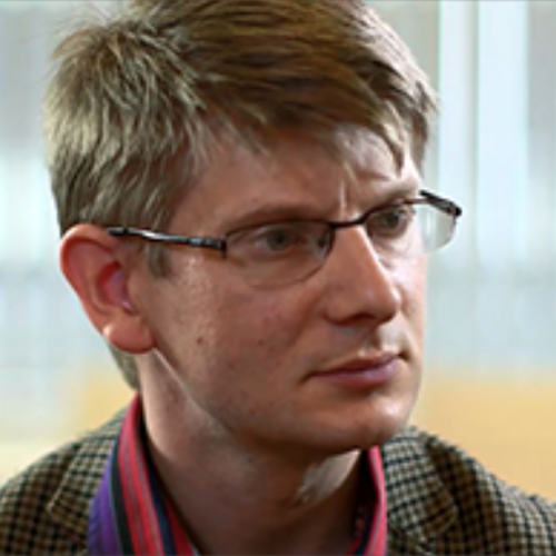 male wearing glasses looking to the right