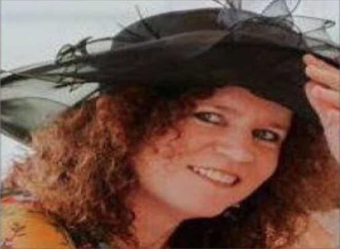 a photograph of a smiling female wearing a black hat for a special occasion 