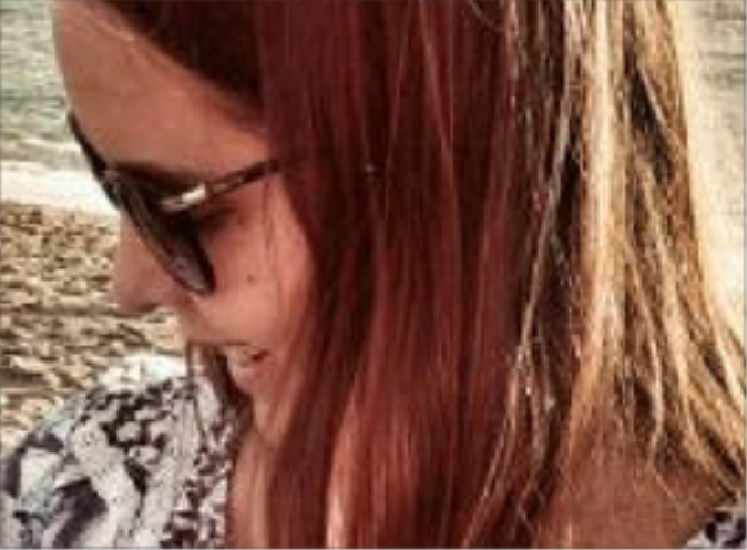 female wearing sunglasses, turned to the right and looking down