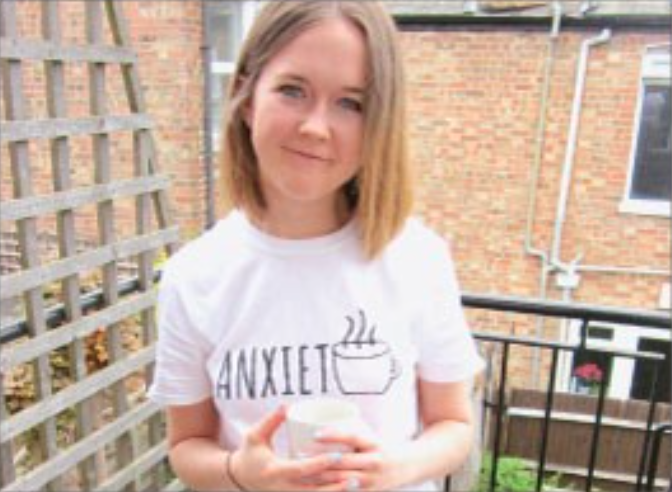 female smiling wearing a while top saying 'anxiety'