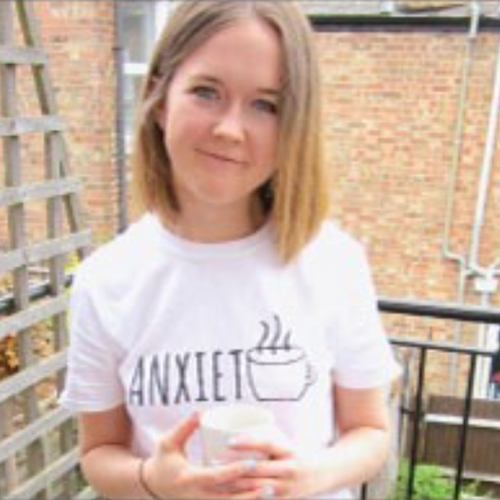 female smiling wearing a while top saying 'anxiety'