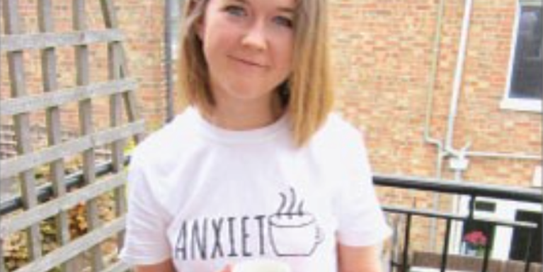 female smiling wearing a while top saying 'anxiety'