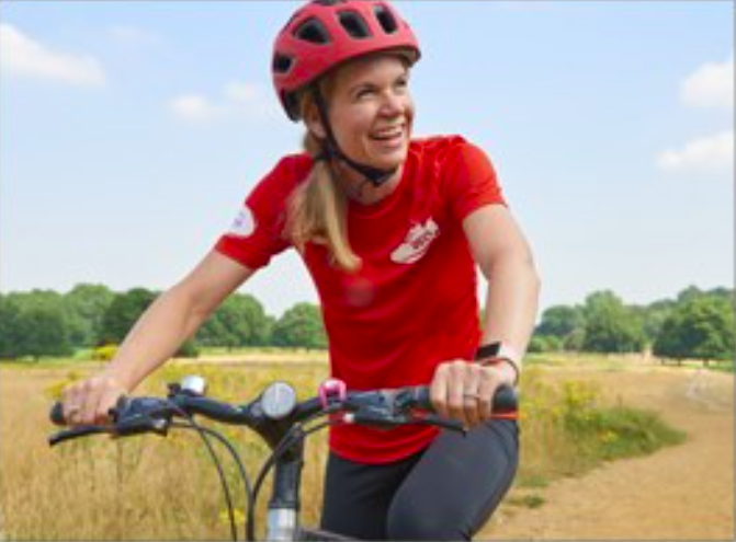 female cycling past a field of golden crops