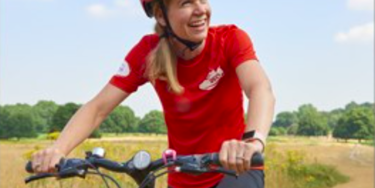 female cycling past a field of golden crops