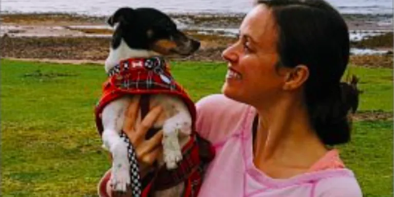 female holding small dog, smiling at it female holding small dog, smiling at it