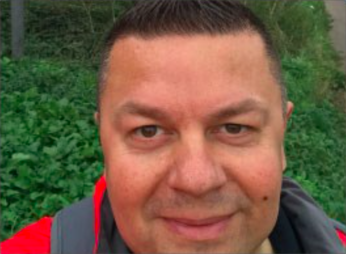 male smiling wearing a high vis jacket