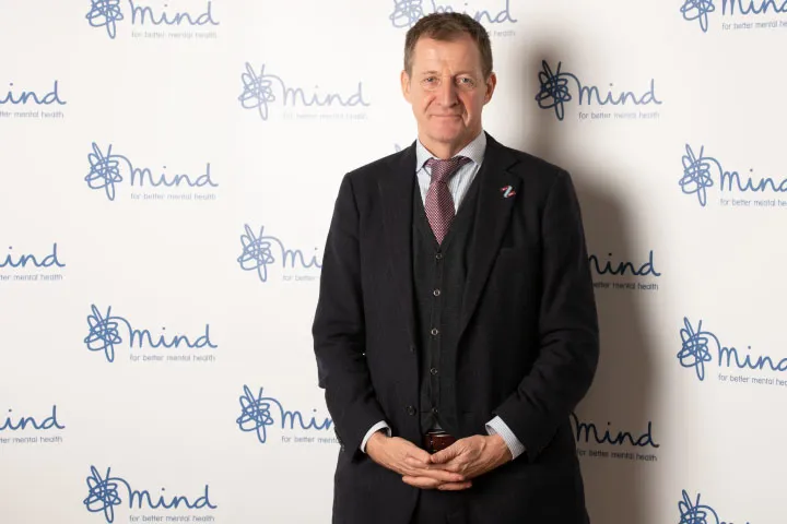Alastair Campbell in front of Mind branded wall looking into the camera