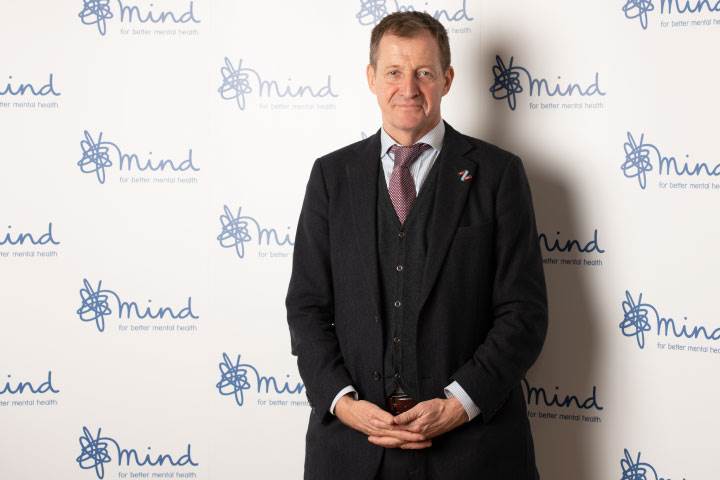 Alastair Campbell in front of Mind branded wall looking into the camera