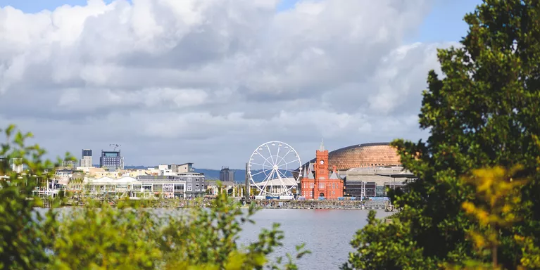 A picture of the Cardiff skyline, with the ferris wheel and river.