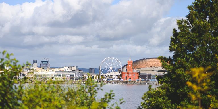 A picture of the Cardiff skyline, with the ferris wheel and river.