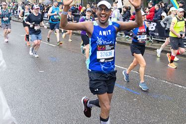 Happy runner smiling with both arms up
