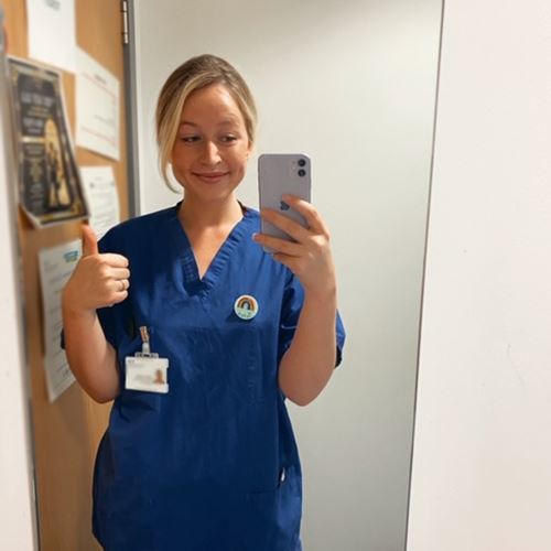 Photograph of nurse Jess in scrubs taking selfie 