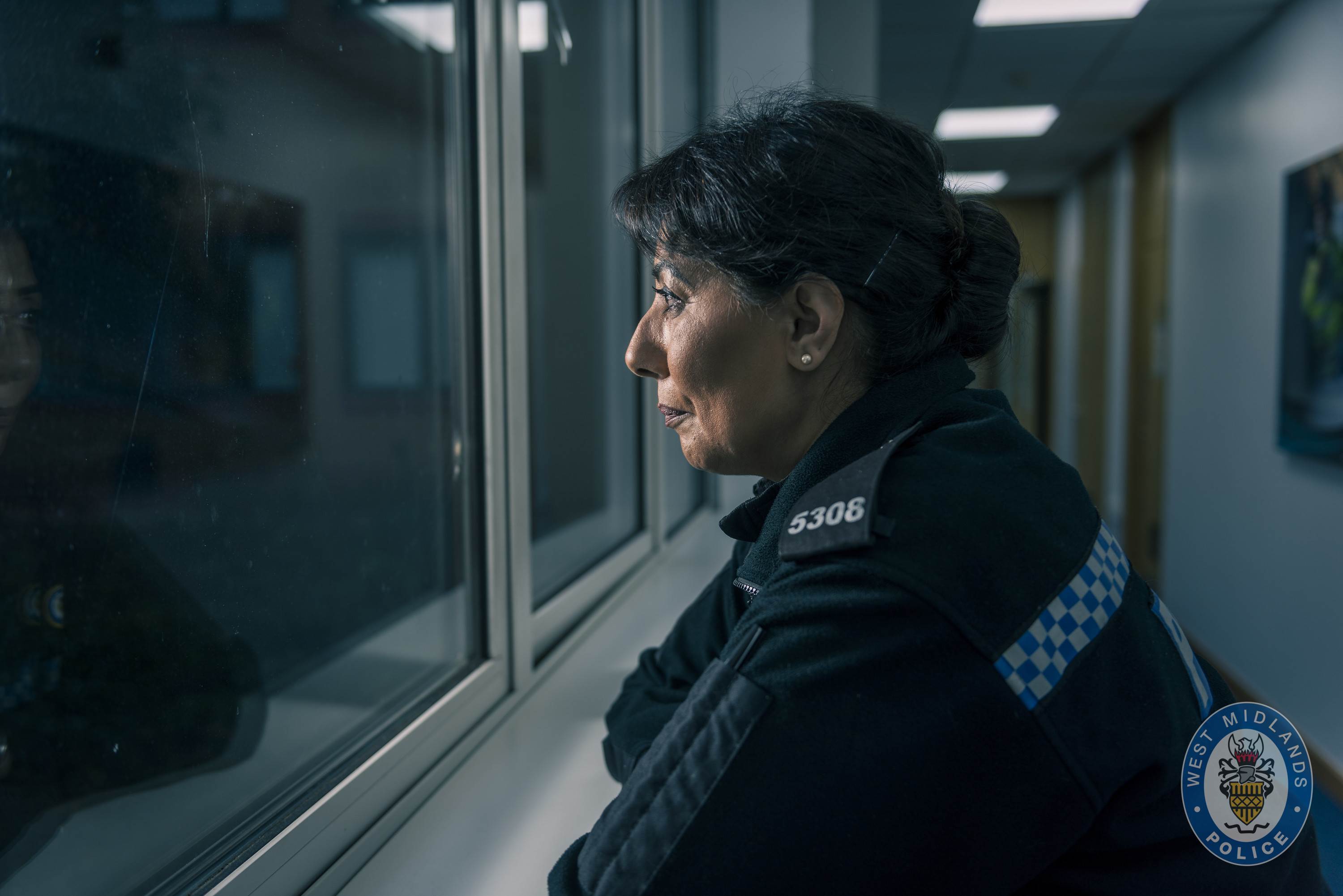 West Midlands Police officer looking through window