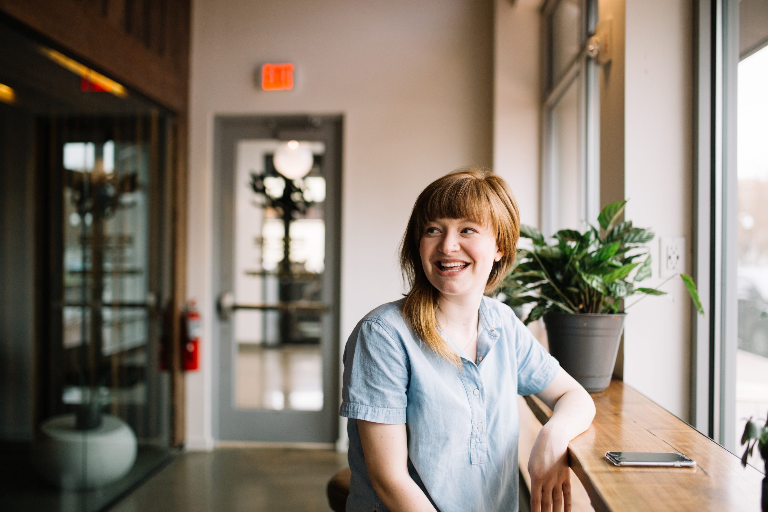Person smiling, sat by a window
