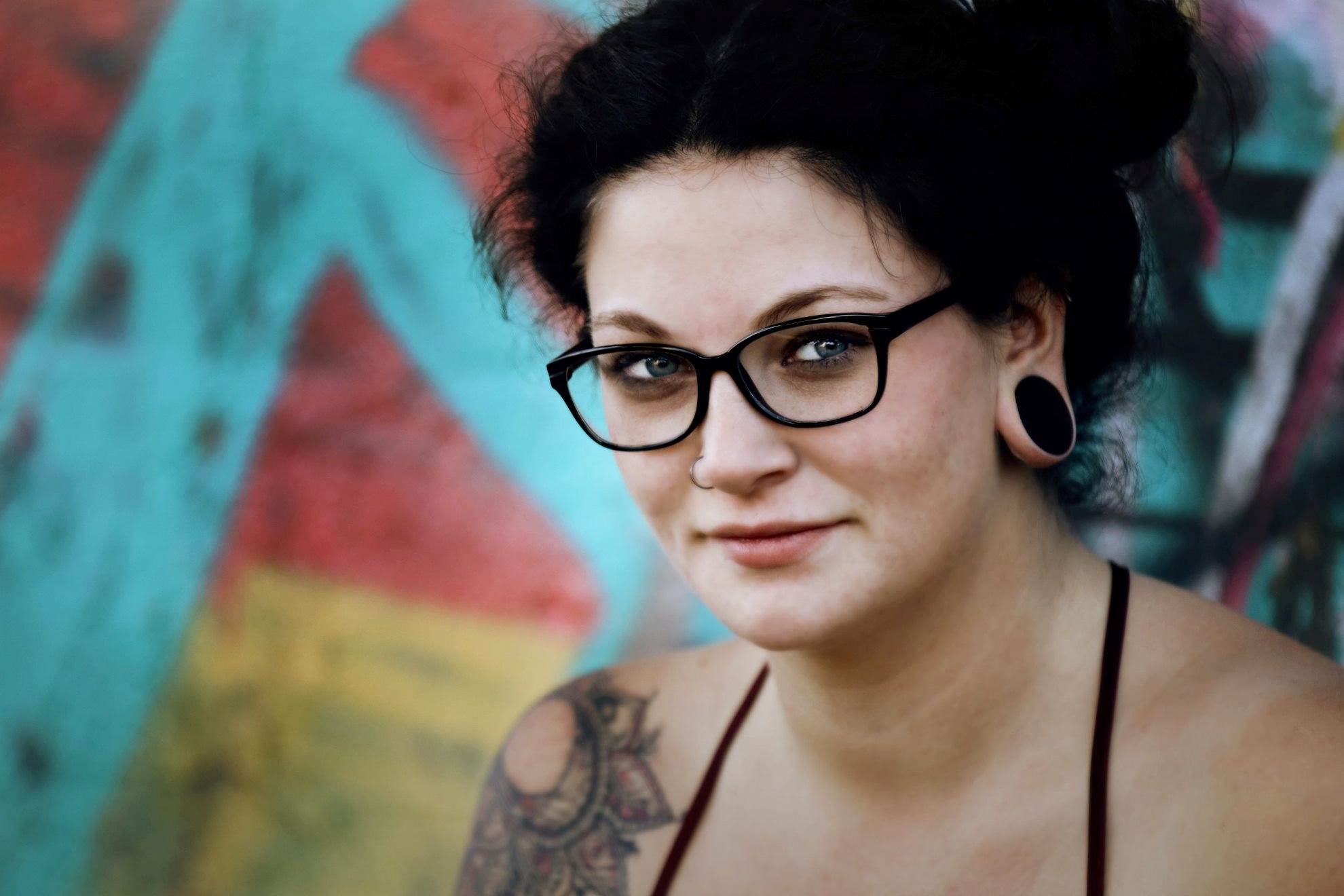 Person with glasses and a shoulder tattoo