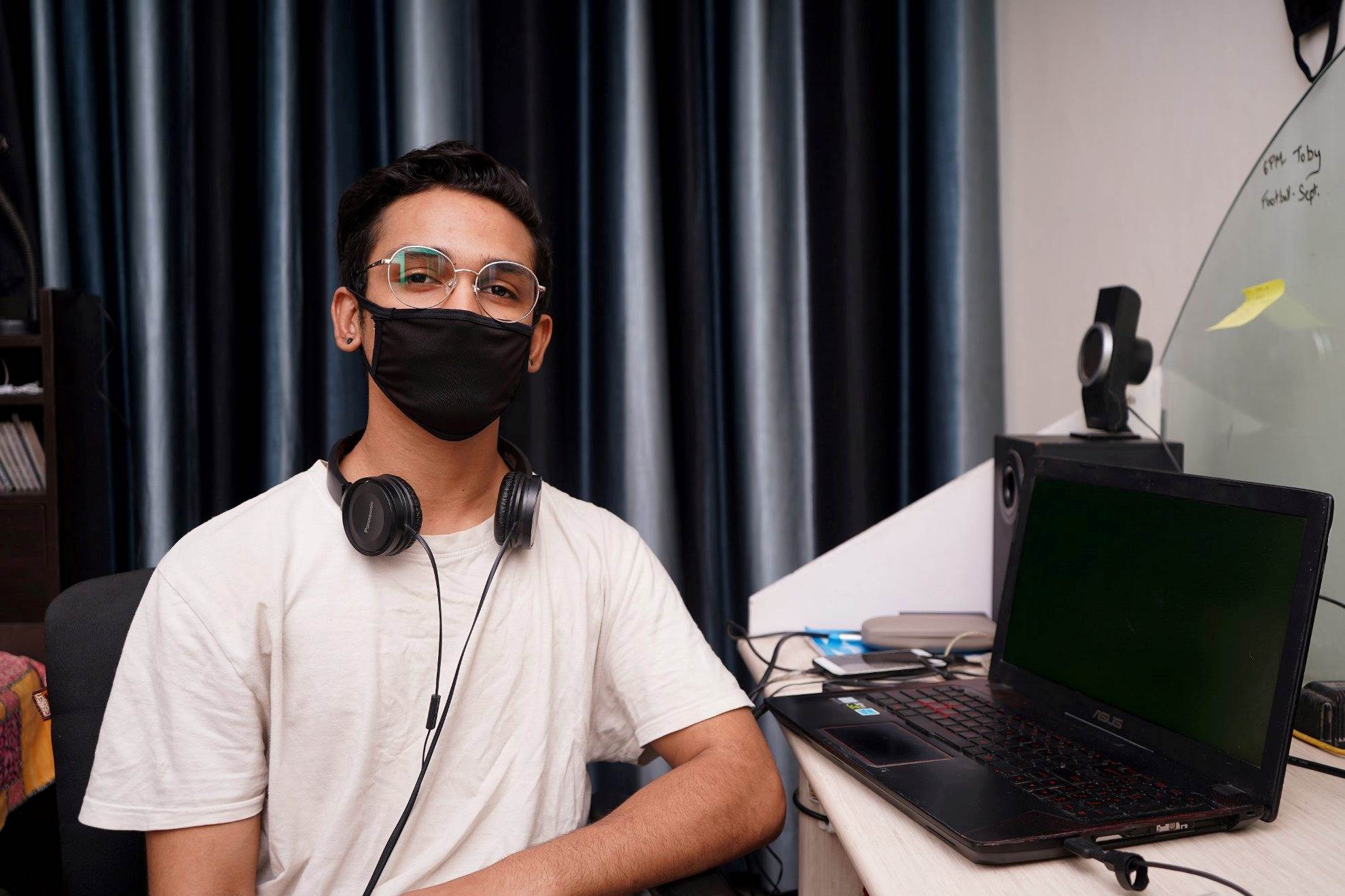 Person with glasses, mask and headphones