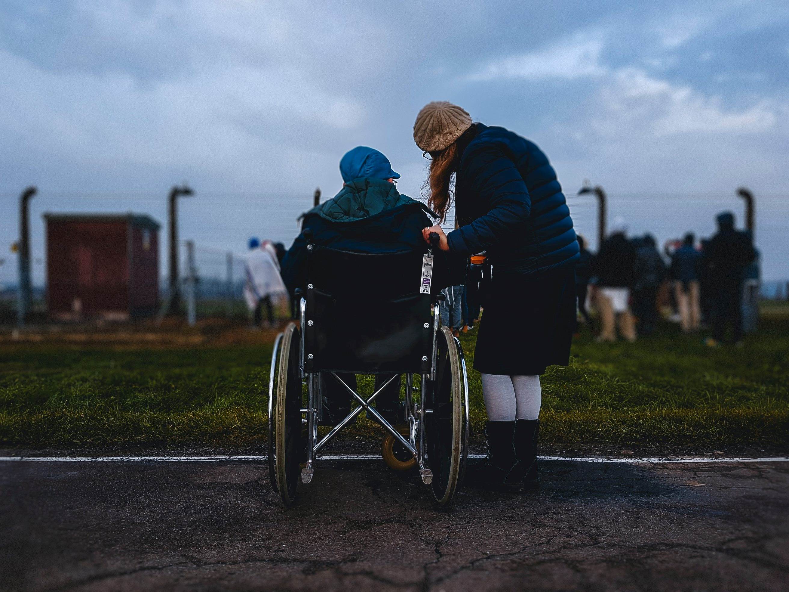 Person in wheelchair next to a person leaning down