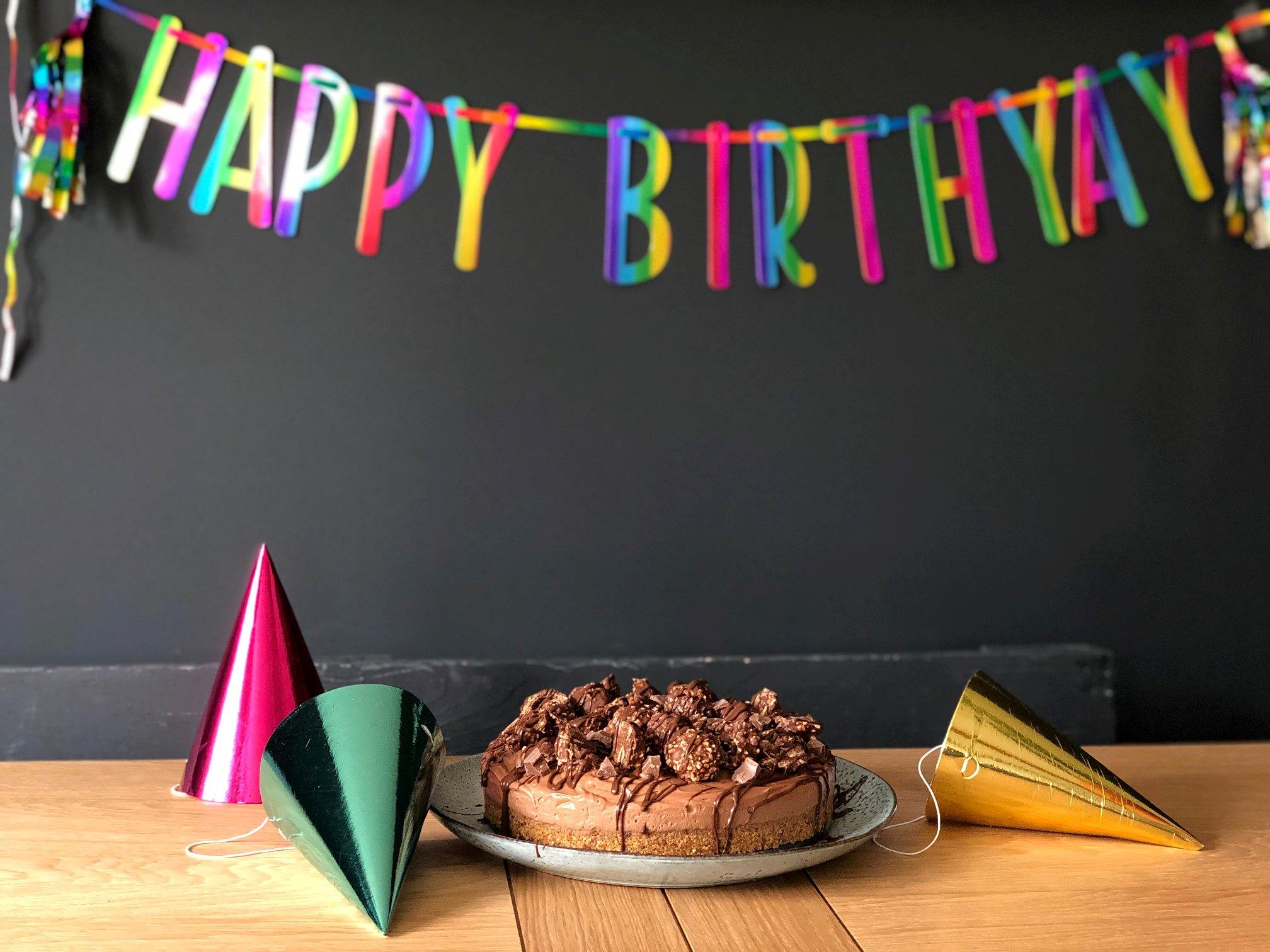 Chocolate birthday cake with a colourful happy birthday banner above