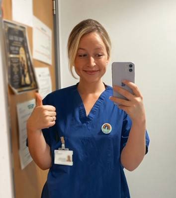 A nurse giving a thumbs up