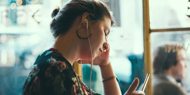 Person listening to music holding a pen