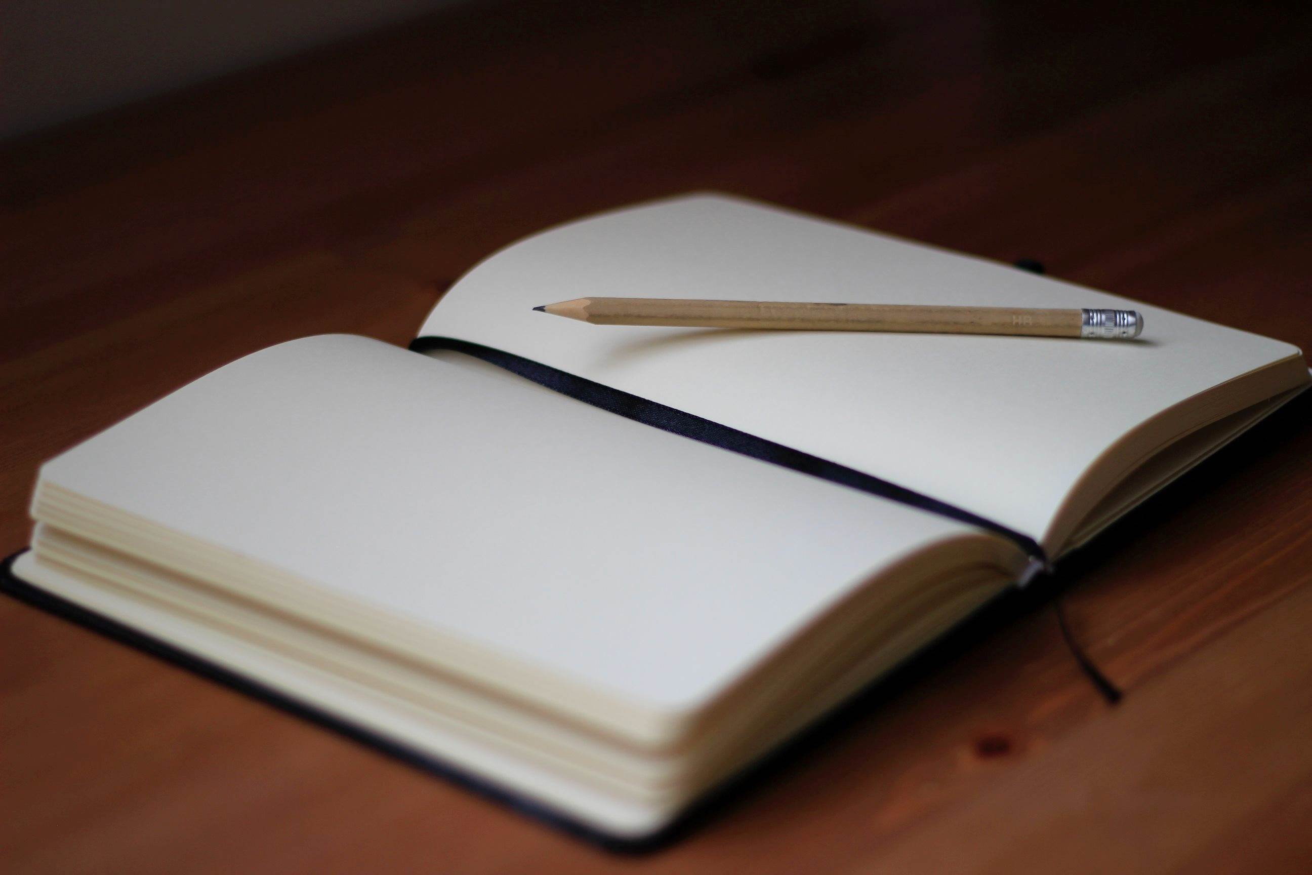 Empty notebook with a pencil on top