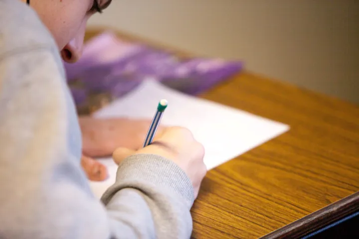 Person writing on paper worksheets